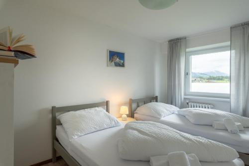 two beds in a room with a window at Sun Valley Apartments in Maishofen