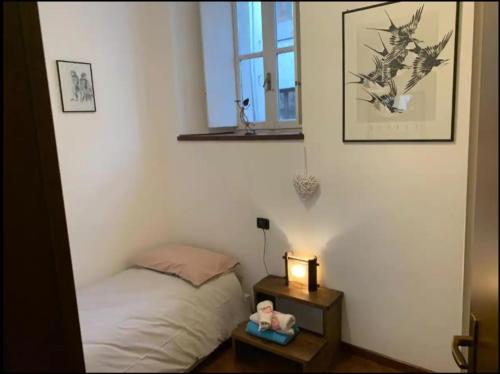 Un dormitorio con una cama y una mesa con una lámpara. en Piazza Volta Apartment, en Como