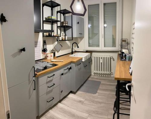 a kitchen with white cabinets and a sink and a counter at La Casa di Mimmi in Mantova