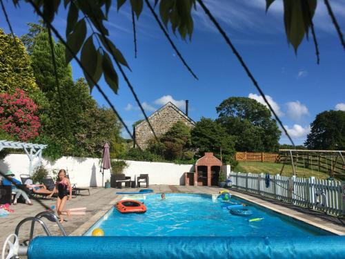 un enfant jouant dans une piscine dans un jardin dans l'établissement Dozmary Cottage, à Launceston