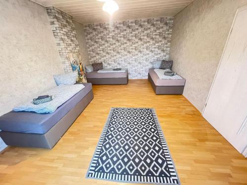 sala de estar con 2 camas y alfombra en KobyHome Apartment en Enger