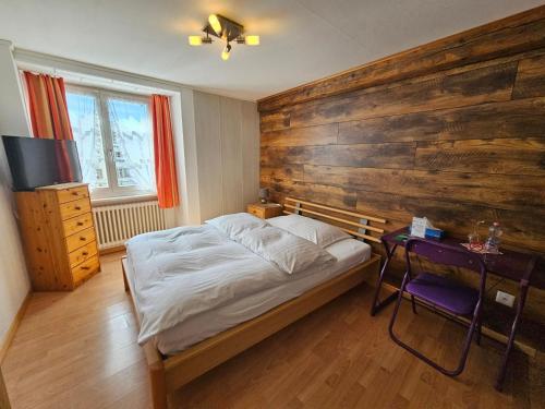 a bedroom with a bed and a wooden wall at Hotel Taverne zur Linde in Bischofszell