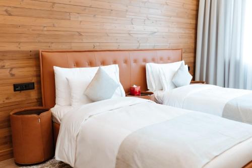 two beds in a hotel room with white pillows at Le Chalet by Amirsoy in Chimgan