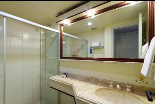 y baño con lavabo, ducha y espejo. en Flat Hotel The Time Berrini - A 200 metros do WTC, en São Paulo