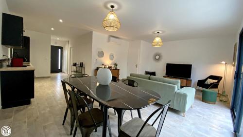 a dining room and living room with a table and chairs at Appart 'Hôtel BreakIsleBed Limoges CHU & Fac Médecine Pharma à Pied parking gratuit in Isle