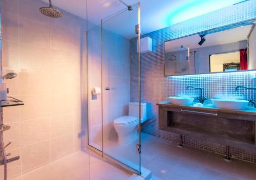 a bathroom with a shower and a toilet and two sinks at I House Chinchin in Seoul