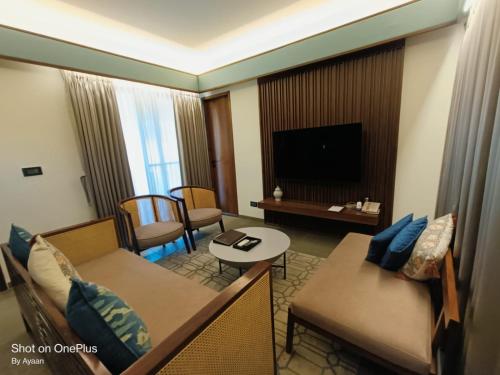 a living room with a couch and a tv in a hotel room at The Golkonda Resort and Spa in Hyderabad