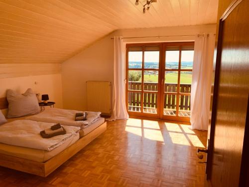 um quarto com uma cama e uma grande janela em Adlerhorst, 4 Schlafzimmer, Blick in die Alpen, Parkplatz em Thyrnau