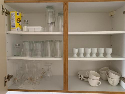 a cupboard filled with lots of dishes and cups at Adlerhorst, 4 Schlafzimmer, Blick in die Alpen, Parkplatz in Thyrnau
