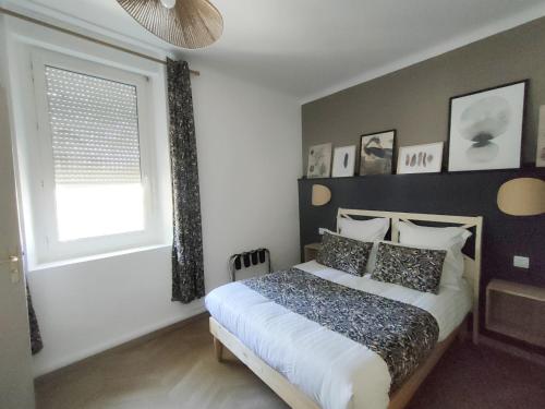 a bedroom with a large bed and a window at Hôtel Restaurant L'Art des Mets by Côté Jardin in Conilhac-Corbières