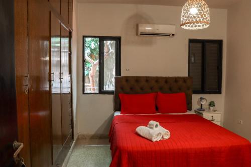 a bedroom with a red bed with a towel on it at Renty Paraguay in Asunción