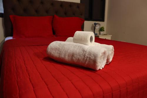 a red bed with a towel on top of it at Renty Paraguay in Asuncion