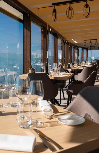 シェーブルにあるBaron Tavernier Hotel Restaurant & SPAのワイングラス付きのテーブルと椅子のあるレストラン