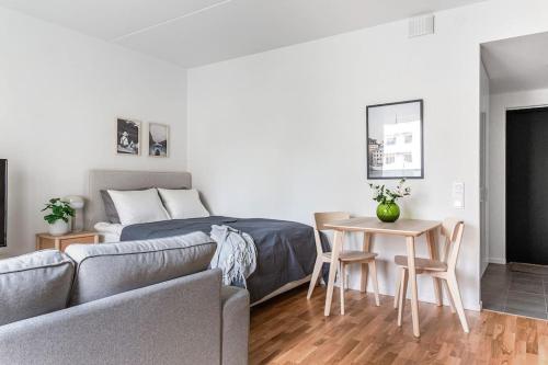 1 dormitorio con cama, mesa y sofá en Modern Stylish Apartment With Balcony In Stockholm, en Järfälla