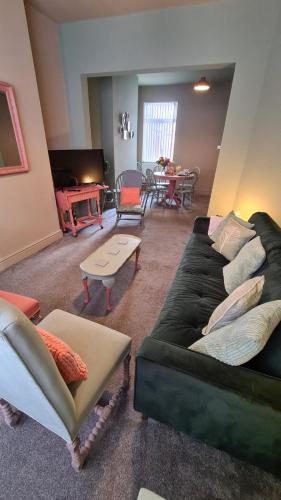 a living room with two couches and a table at Jasper's a cosy comfortable 4 bedroom house in Meir close to Trentham Gardens in Stoke on Trent