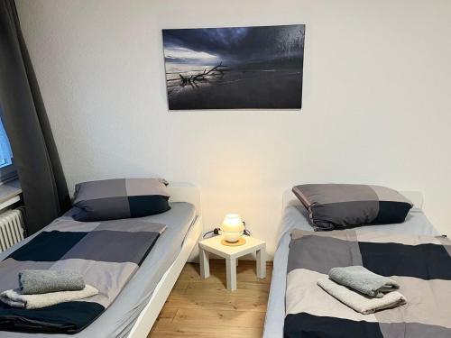 two beds in a room with a picture on the wall at Low Budget Apartment Cologne in Cologne