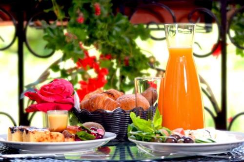 a table with plates of food and a glass of orange juice at Q Hotel in Beirut