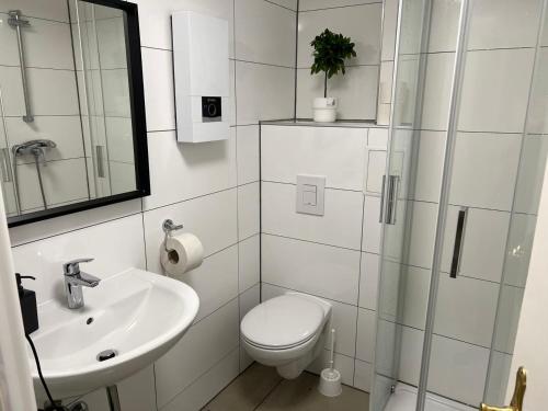 a white bathroom with a toilet and a sink at Low Budget Apartment Cologne in Cologne