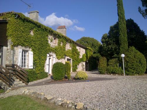 an ivy covered building with a gravel driveway at Quatre Vents in Lagarrigue