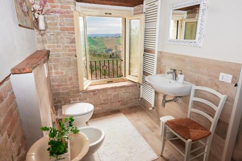 a bathroom with a sink and a toilet and a window at Dimora nel Castello di Loretello in Loretello