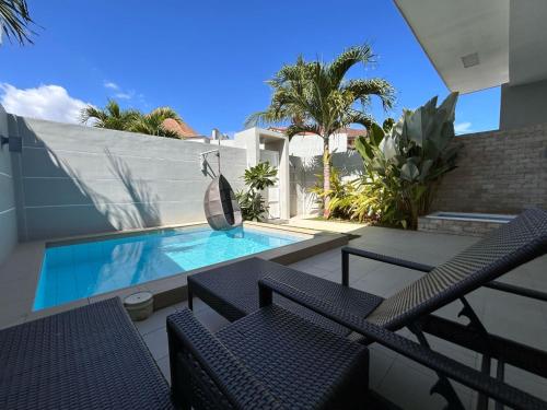 a patio with chairs and a swimming pool at Pineale Villas, Resort and Spa in Panglao