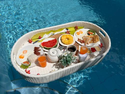 a tray of food in a boat in a pool at Pineale Villas, Resort and Spa in Panglao