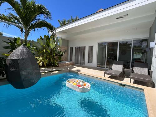 a swimming pool with a bowl of fruit in a basket in the middle at Pineale Villas, Resort and Spa in Panglao
