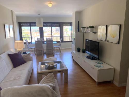 a living room with a couch and a tv at Cozy Apartment in a Beachfront Complex in Mareny Blau