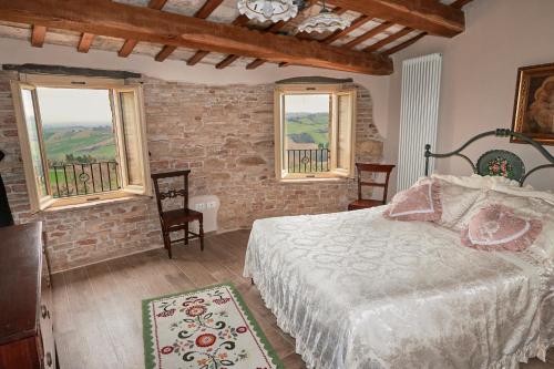 a bedroom with a bed and two windows at Dimora nel Castello di Loretello in Loretello