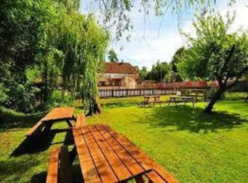 a wooden bench sitting in the grass in a park at George & falcon in Southampton