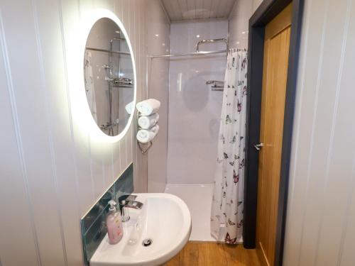 a white bathroom with a sink and a shower at Arthur in Mold