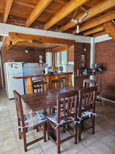a kitchen with a wooden table and chairs at Cabañas Huinca Mapu - Sierra de los Padres in Sierra de los Padres