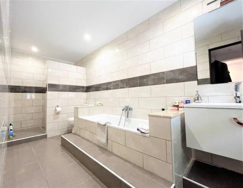 een grote witte badkamer met een bad en een wastafel bij Villa Cortés - 20 Minutes From Puerto Banús in Estepona
