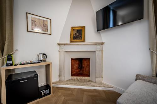a living room with a fireplace and a television at Residenza d'epoca Poliziano in Florence
