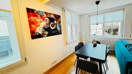 a living room with a table and a painting on the wall at Apartment II für 4 Aalen I Wlan I Netflix in Aalen