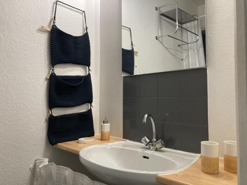 une salle de bain avec un lavabo et un miroir dans l'établissement Yescale - Le petit Nicolas, à La Rochelle