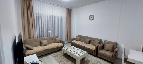 un soggiorno con 2 divani e un tavolo di 1st Story Apartment for rent 2 bedrooms', 1 balcony, 1 saloon & kitchen a Ferizaj