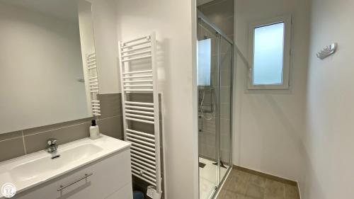 a white bathroom with a sink and a shower at Appart 'Hôtel BreakIsleBed Limoges CHU & Fac Médecine Pharma à Pied parking gratuit in Isle