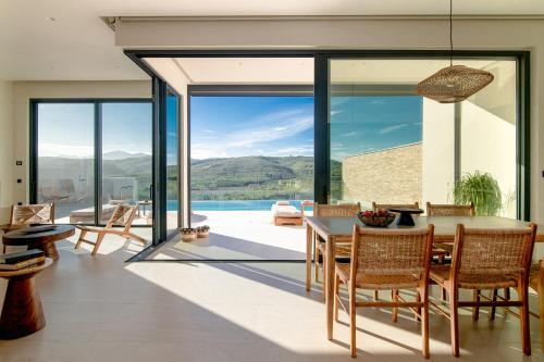 a dining room with a table and glass doors at Anantia Villa 1 - Scenic View, Luxury Experience in Episkopi (Heraklion)