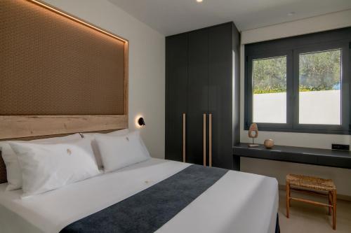 1 dormitorio con cama blanca y ventana en Anantia Villa 1 - Scenic View, Luxury Experience en episkopi-heraklion