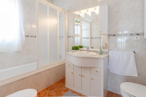 a white bathroom with a sink and a shower at Seaside Elegance by Fidalsa in La Manga del Mar Menor