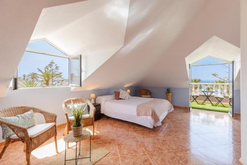 1 dormitorio con 1 cama, mesa y sillas en Seaside Elegance by Fidalsa, en La Manga del Mar Menor