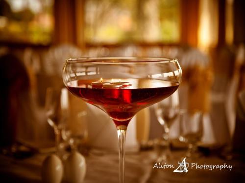 a glass of wine sitting on top of a table at Old Manor Hotel in Lundin Links