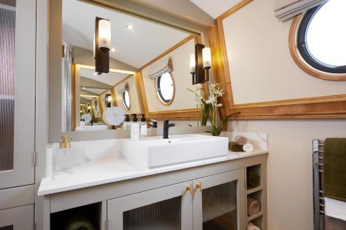 a bathroom with a sink and a mirror at Luxus Hausboot am Pichelssee - Madame President in Berlin