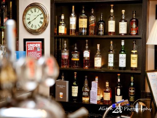 a shelf filled with lots of bottles of alcohol at Old Manor Hotel in Lundin Links
