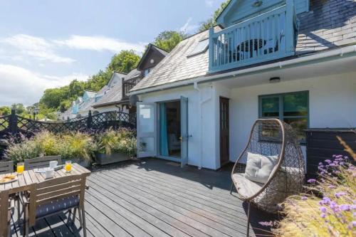 a wooden deck with a table and chairs on a house at 2 Bedrooms overlooking Little Petherick Creek in Little Petherick