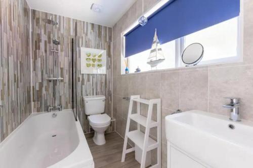 a bathroom with a tub and a toilet and a sink at 2 Bedrooms overlooking Little Petherick Creek in Little Petherick