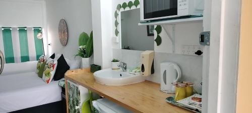 a tiny kitchen with a sink and a microwave at Nationwide Motel in Gympie