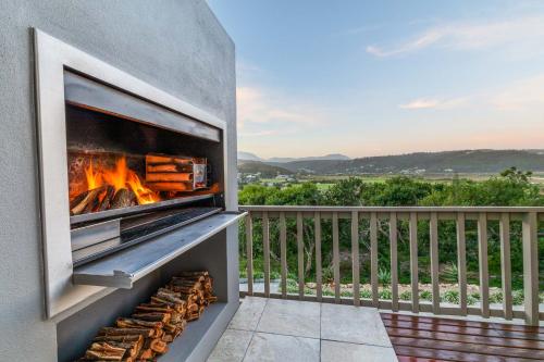 a fireplace on a balcony with a view at The Milkwoods Luxury Living in Mossel Bay
