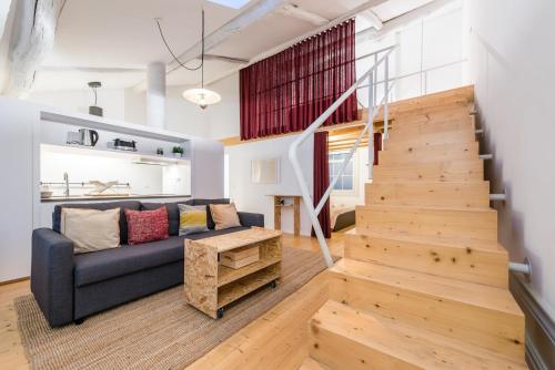 a living room with a couch and a staircase at GuestReady - Mezzanine at the Bridge in Porto